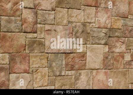 Regardez en texture mur de briques en pierre historique dans les tons de beige, rouge et marron clair Banque D'Images