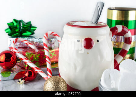 Santa Claus Mug avec du chocolat chaud & Marshmellows avec les cannes et bâtons de menthe fraîche et arcs Satin présente adoucit Marais Banque D'Images