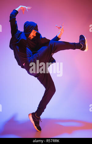 La silhouette d'un homme hip hop break dancer dancing sur fond coloré Banque D'Images