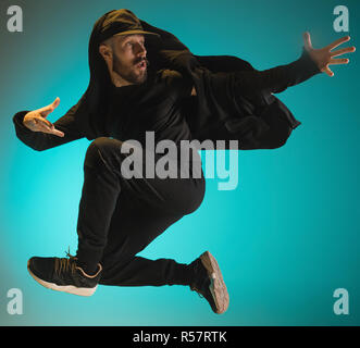 La silhouette d'un homme hip hop break dancer dancing sur fond coloré Banque D'Images