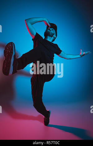 La silhouette d'un homme hip hop break dancer dancing sur fond coloré Banque D'Images