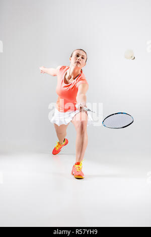 Jeune femme jouer au badminton sur fond blanc Banque D'Images