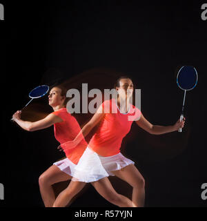 Jeune femme jouer au badminton sur fond noir Banque D'Images