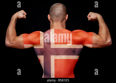Le retour d'un jeune homme sportif portant un T-shirt avec le drapeau national de la Norvège sur un arrière-plan noir isolé. La notion de fierté nationale et pa Banque D'Images