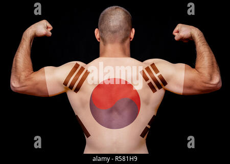 Le retour d'un jeune homme athlétique portant un T-shirt avec le drapeau national de la Corée du Sud sur un fond noir isolé. La notion de fierté nationale Banque D'Images