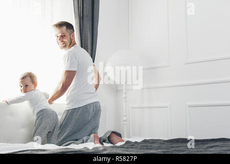 Heureux père avec son fils jouer à la maison sur le lit Banque D'Images