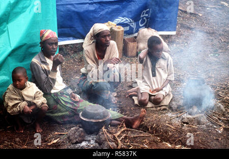 1994 - Une famille de réfugiés est assis près d'un feu couvant dans le camp près de Goma au Zaïre Banque D'Images