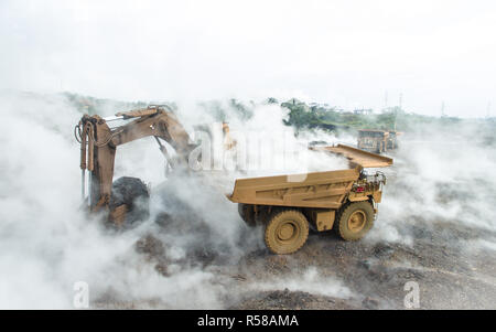 Accueil chaleureux et enfumé de scories matière à charger dans un camion-benne minière, dans les mines de nickel au sud de Sulawesi, Indonésie Banque D'Images