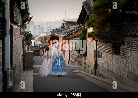 Retour de deux femmes portant hanbok marcher dans les maisons de style traditionnel du village de Bukchon Hanok à Séoul, Corée du Sud. Banque D'Images