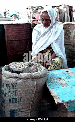 Une femme somalienne est assis face à la caméra et derrière une table en attente de passer des grains pour les résidents de son centre d'alimentation de Mogadishu, Somalie. C'est l'un des 35 sites qui avaient les livraisons de vivres escorté par les forces de la coalition. Cette mission est en appui direct à l'Opération Restore Hope. Banque D'Images