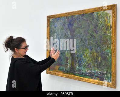 Cottbus, Allemagne. 30Th Nov, 2018. Ulrike Kremeier, directeur de l'état de Brandebourg Musée d'Art Moderne (BLMK), explique la peinture à l'huile "Saule pleureur" de 1918/19 par le peintre Claude Monet dans la nouvelle exposition "La nostalgie de la lumière". L'exposition est ouverte aux visiteurs à partir de 01.12.2018. L'exposition de groupe associe des peintures de la fin de l'impressionnisme français avec les positions correspondantes de la peinture de l'Allemagne et la Russie. Rarement illustré par des œuvres de artistes provenant de collections privées ou de musées sont présentés. Crédit : Patrick Pleul/dpa-Zentralbild/ZB/dpa/Alamy Live News Banque D'Images