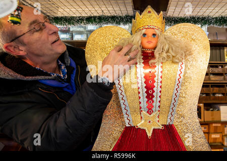 30 novembre 2018, la Bavière, Nuremberg : Ralf ajuste ses cheveux sur une tresse ange à son stand au marché de Nuremberg. Photo : Daniel Karmann/dpa Banque D'Images