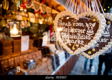 30 novembre 2018, la Bavière, Nuremberg : Gingerbread hearts avec l'inscription "Salutations du Marché de Noël de Nuremberg' sont exposées pour la vente à un stand au marché de Noël de Nuremberg. Photo : Daniel Karmann/dpa Banque D'Images