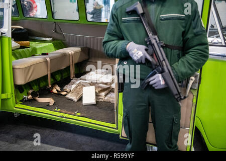 30 novembre 2018, Hambourg : Au cours d'une conférence de presse, un agent des douanes est à côté d'un VW T1 van dans lequel la douane saisi environ 100 kilogrammes de cocaïne. Les fonctionnaires ont découvert les 300 kilos de drogue dans un récipient de la République dominicaine au début de novembre. Photo : Daniel Reinhardt/dpa Banque D'Images