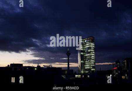 30 novembre 2018, en Rhénanie du Nord-Westphalie, Düsseldorf : Le soleil se couche derrière une tour à bureaux au centre-ville de Düsseldorf. Photo : Martin Gerten/dpa Banque D'Images