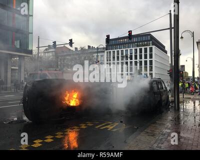 Bruxelles, Belgique. 30Th Nov 2018. Seulement quelques centaines de mètres de la Commission européenne, deux voitures de police ont brûlé dans le quartier européen de Bruxelles. La police a bloqué les routes hors de barbelés, entre autres choses. De nombreux manifestants masqués avec des gilets jaunes ont été marcher dans les rues. Encore et encore des explosions de pétards pouvait être entendu. Photo : Marek Majewsky/dpa dpa : Crédit photo alliance/Alamy Live News Banque D'Images