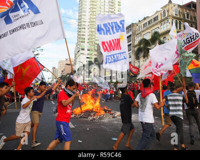 Manille, Philippines. 20 fév, 2012. Les protestataires sont vus holding flags lors de l'exécution autour de l'effigie du Président Duterte brûler pendant la manifestation.groupes gauchistes étape Bonifacio Journée de protestation à Mendiola et à l'ambassade des États-Unis, à Manille, sur le 155e anniversaire de la naissance d'un héros philippin Andres Bonifacio, les travailleurs de la demande pour une véritable liberté de la contractualisation et de la pauvreté. Faisant part des diverses questions, notamment le travail, l'ouest de la mer des Philippines, le cas de la greffe de l'ancienne Première Dame Imelda Marcos et l'annulation de parler de paix entre le gouvernement et les rebelles communistes. (Cre Banque D'Images