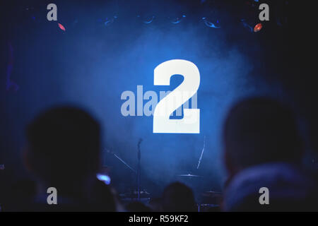 Silhouettes d'un concert public en attente de départ. Sur l'écran, un compte à rebours pour le début de la performance. Fond sombre, un grand nombre sur le SCR Banque D'Images