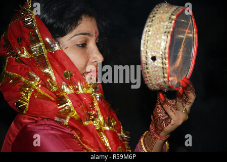 Woman Looking at lune à travers un tamis au cours de Karva Chauth Banque D'Images