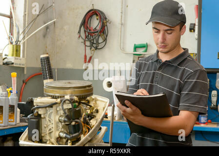 Un mécanicien contrôle du moteur petit bateau Banque D'Images