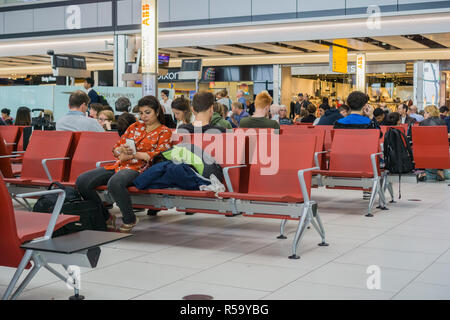 10 septembre, 2017 Londres/UK - des gens assis sur les chaises dans l'une des zones d'attente à l'aéroport d'Heathrow Banque D'Images