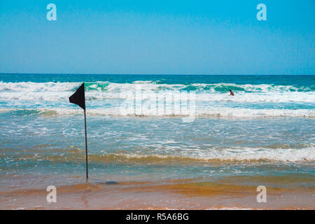 Un indicateur d'alerte noire marquant la limite de la zone de baignade sécuritaire lors d'une belle plage avec ciel bleu et une mer turquoise en Israël Banque D'Images