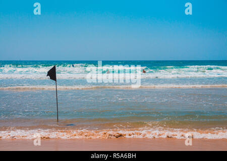 Un indicateur d'alerte noire marquant la limite de la zone de baignade sécuritaire lors d'une belle plage avec ciel bleu et une mer turquoise en Israël Banque D'Images