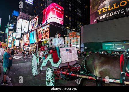 La ville de New York, USA - 30 juillet 2018 : transport de chevaux pour les touristes sur Times Square de nuit avec des gens autour et de grands écrans de publicité à Manhattan Banque D'Images