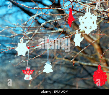 Étoile rouge de Noël et le cœur sur des rameaux et branches couvertes de givre dans la forêt Banque D'Images