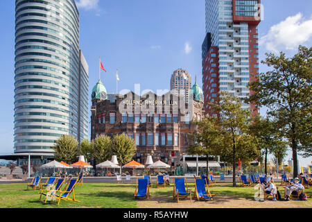 Rotterdam, Pays-Bas - 18 septembre 2018 : la lecture d'un livre dans une chaise de plage en face du célèbre Hôtel New York de Rotterdam Banque D'Images