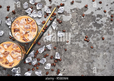 Le froid brassé café glacé dans grand verre avec de la glace et les grains de café sur fond de béton gris humide. Chocolat, vanille, caramel ou café glacé à la cannelle je Banque D'Images