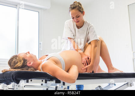Ostéopathie structurelle session à une femme enceinte. Banque D'Images