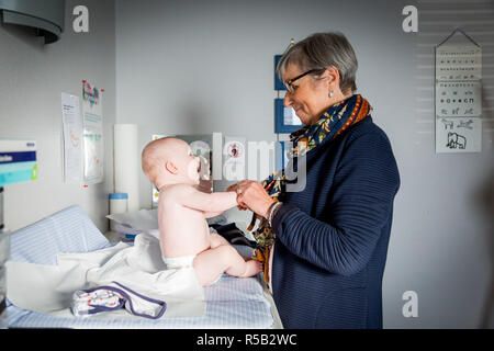 Médecin généraliste avec bébé, Geveze, France. Banque D'Images