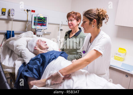 Patient âgé avec sa fille à l'urgence d'un hôpital privé, la France. Banque D'Images