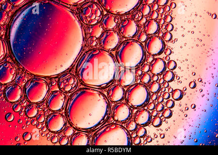 Résumé fond de close up detail dans de l'huile végétale gouttelettes/bulles sur la surface de l'eau avec un fond coloré Banque D'Images