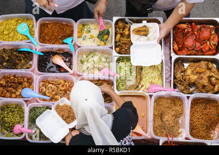 Passage tiré de personnes achètent des aliments plus de variété de délicieux plats cuisinés accueil malaisien vendus à street market stall à Kota Kinabalu Sabah. Banque D'Images