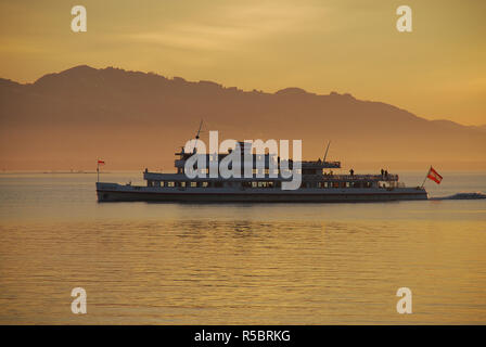 Lindau, Allemagne : une vue sur un bateau sur le lac de Constance, dans la distance, l'Autriche et la Suisse, au coucher du soleil en été Banque D'Images