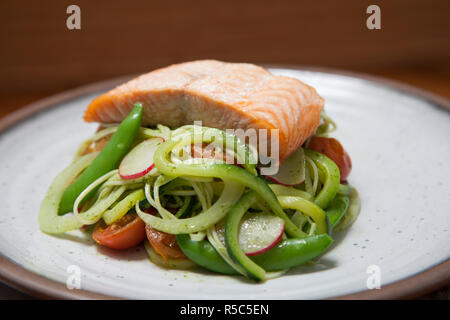 Saumon à la vapeur sur un lit de salade de nouilles et de courgettes Banque D'Images