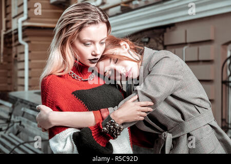 Hug et poser. Deux modèles photo portant des vêtements élégants qui pose pour étreindre l'extérieur permanent magazine Banque D'Images
