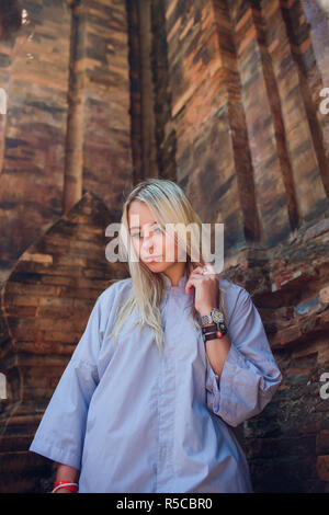 Une jeune fille dans une robe bleu prend une photo d'elle-même Selfies contre le mur du temple en lunettes de soleil. CONCEPTION DE LA RELIGION MODERNE Banque D'Images