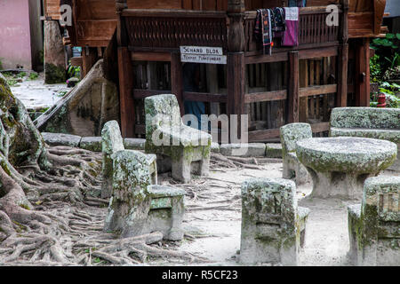 L'Indonésie, Sumatra, l'île de Samosir, Lac Toba, Ambarita, Siallagan village, ancienne en pierre de Batak des chaises et une table en pierre, qui constituent une ancienne cour intérieure, où les anciens du village tenu conseil. Banque D'Images