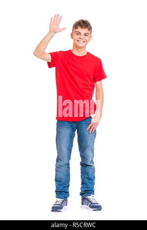 Full Length portrait of young caucasian teen boy isolé sur fond blanc. Funny teenager étend sa main droite vers le haut de l'accueil. Beaux enfants. Banque D'Images