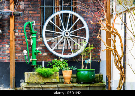 Roue en bois,eau pompe à main sur un mur de la maison. Banque D'Images