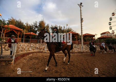 La ville de Gaza, bande de Gaza, 01 décembre 2018. Palestiniens monter des chevaux lors d'un concours hippique de la ville de Gaza, le 29 novembre, 2018. Le peuple palestinien à Gaza Fédération Équestre organisée le jeudi soir un concours local pour le saut d'obstacles sous le titre "Will et de l'espoir", marquant la prochaine Journée internationale des personnes handicapées, qui tombe le 3 décembre de chaque année. Un total de 35 participants et leurs familles s'est joint à un rassemblement public de personnes handicapées à un club hippique du nord de la ville de Gaza pour montrer le soutien aux personnes handicapées. Source : Xinhua/Alamy Live News Banque D'Images