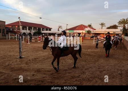 La ville de Gaza, bande de Gaza, 01 décembre 2018. Palestiniens monter des chevaux lors d'un concours hippique de la ville de Gaza, le 29 novembre, 2018. Le peuple palestinien à Gaza Fédération Équestre organisée le jeudi soir un concours local pour le saut d'obstacles sous le titre "Will et de l'espoir", marquant la prochaine Journée internationale des personnes handicapées, qui tombe le 3 décembre de chaque année. Un total de 35 participants et leurs familles s'est joint à un rassemblement public de personnes handicapées à un club hippique du nord de la ville de Gaza pour montrer le soutien aux personnes handicapées. Source : Xinhua/Alamy Live News Banque D'Images