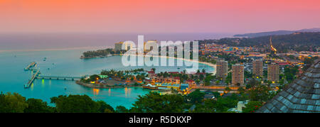 Des vue sur ville et littoral allumé au coucher du soleil, Ocho Rios, St Ann Parish, Jamaïque, Caraïbes Banque D'Images