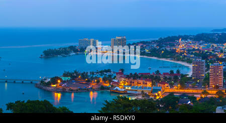 Des vue sur ville et littoral allumé au crépuscule, Ocho Rios, St Ann Parish, Jamaïque, Caraïbes Banque D'Images