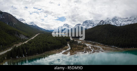 Vue aérienne paysage panoramique d'un lac glaciaire entouré de montagnes rocheuses canadiennes pendant une journée nuageuse. Prises à Banff, Alberta, Canada. Banque D'Images