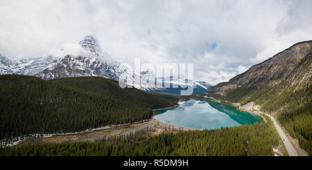 Vue aérienne paysage panoramique d'un lac glaciaire entouré de montagnes rocheuses canadiennes pendant une journée nuageuse. Prises à Banff, Alberta, Canada. Banque D'Images