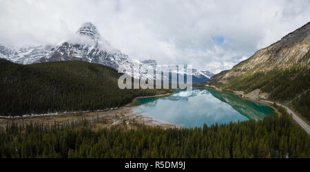 Vue aérienne paysage panoramique d'un lac glaciaire entouré de montagnes rocheuses canadiennes pendant une journée nuageuse. Prises à Banff, Alberta, Canada. Banque D'Images